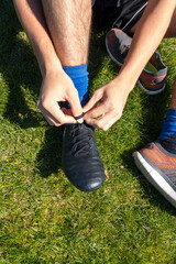 Soccer European football player putting on black cleats
