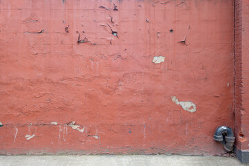 distant image of weathered and distresed painted concrete wall with chips of paint and cracks