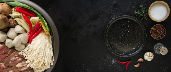Japanese Sukiyaki in traditional Cast Iron Pot. Chabu sukiyaki and Empty plate on a dark metal background. Top view with copy space.