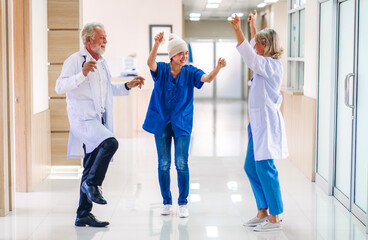 Professional medical doctor team with stethoscope in uniform discussing and dancing with happy...