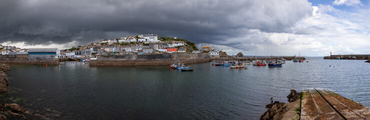 Fototapeta na wymiar Panoramic view of the harbour at Mevagissey in Cornwall on a dramatic stormy summer afternoon