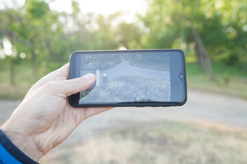 Man taking photo of forest with his smartphone.