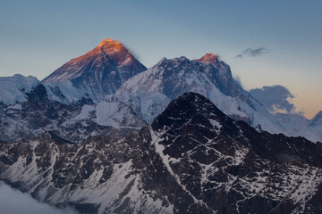 Mounts Everest and Lhotse at sunset with tops lightened by the last golden sunlight