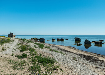 Fototapeta na wymiar summer landscape with a rocky sea shore, remnants of an old concrete structure in the water, Saaremaa Island, Sorves Peninsula, Estonia