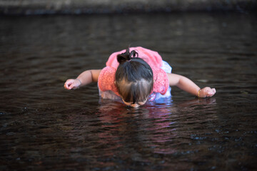 little girl portrait on the river 
drinking water from the river 