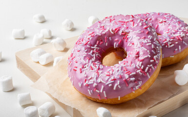 Fruit doughnut on a light background. Sweet marshmallow doughnut on a wooden Board.