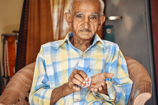 Portrait Of An Old Indian Man Taking Medication