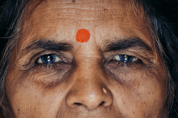 Closeup shot of eyes of an old Indian lady with bindi