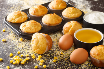Recipe for corn muffins in a baking dish and ingredients close-up on the table. horizontal