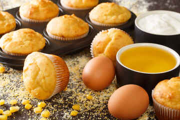 Traditional corn muffins in a baking dish and ingredients close-up on the table. horizontal
