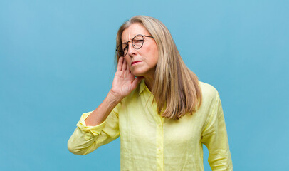 middle age pretty woman looking serious and curious, listening, trying to hear a secret...