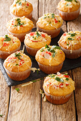 Freshly baked corn muffins with crab meat, herbs and cheese close-up on a slate board on the table. vertical
