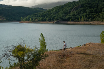 Young teenage man walking alone by the lake