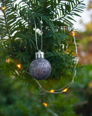 silver shiny christmas ornament hanging on the tree