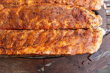 Marinated BBQ pork ribs on a wooden backyard table. Preparation process of barbeque for Grilling, Smoking, Baking and Roasting. Lifestyle concept.