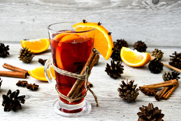 Christmas mulled wine with spices and orange on wooden rustic background. Selective focus. Anise...