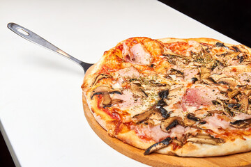 Fresh pizza with bacon, mushrooms and cheese on a light background. Close-up, selective focus