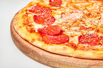 Pizza with salami, bacon and cheese on a light background. Close-up, selective focus