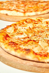 Pizza with cheese, bacon and tomatoes on wooden board. Close-up, selective focus