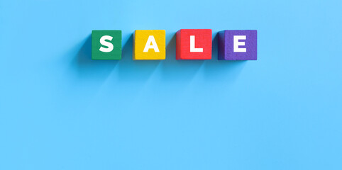 Obraz premium Sale word on multicolored wooden cubes on blue background