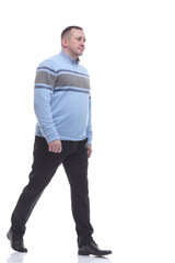 Naklejka premium in full growth. casual man in a knitted sweater walking forward