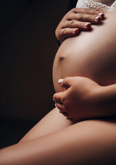 Young pregnant woman sitting on sofa close up