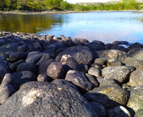 Large black stones on the lake shore