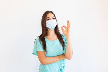Coronavirus outbreak: Woman with a medical disposable mask to avoid contagious viruses, Showing OK sign. Corona virus prevention. Concept of coronavirus quarantine. Attention