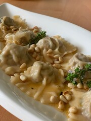 Zubereitung von Steinpilzravioli mit Pinienkernen