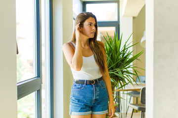 young pretty woman looking serious and curious, listening, trying to hear a secret conversation or...