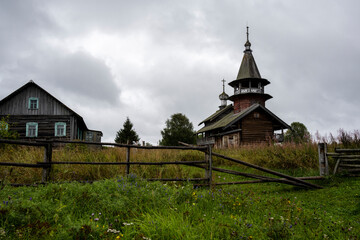 wooden ancient church on the island among the trees during the rain