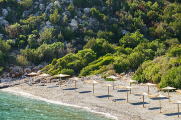 Greek rocky beach with parasols