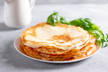 Thin homemade pancakes. Light background. Beautiful and delicious breakfast at home or in the cafe.