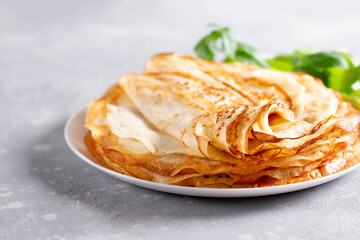 Thin homemade pancakes. Light background. Beautiful and delicious breakfast at home or in the cafe.