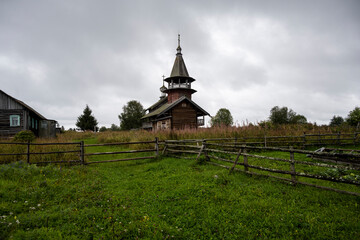 wooden ancient church on the island among the trees during the rain