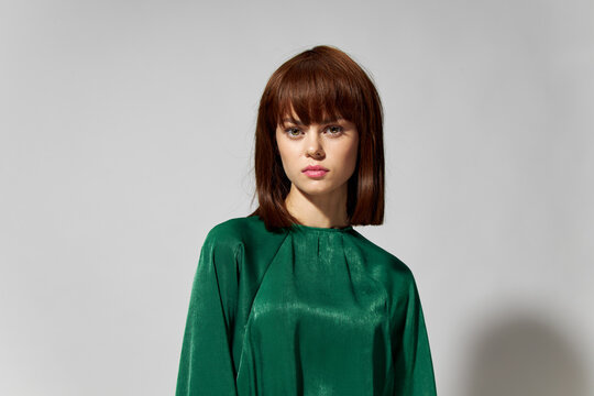 Woman in green fashion dress model with a hairstyle.