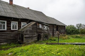 landscape with rustic wooden houses of a very old construction against the background of a gray northern sky