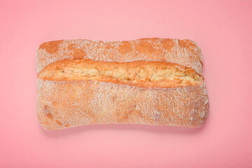 Freshly baked ciabatta bread on a pink background, top view