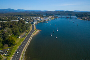 Fototapeta na wymiar Aerial view of Bateman’s Bay on the New South Wales South Coast, Australia, showing boats and yachts moored looking toward Clyde River and Clyde River Bridge 