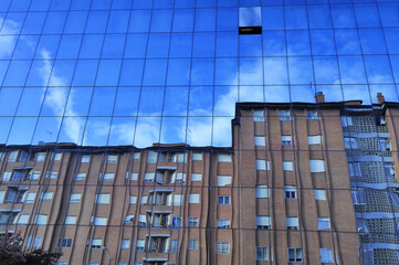 blue glass wall with windows and reflection