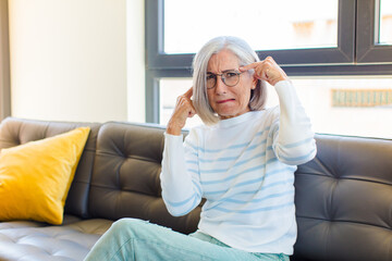 middle age pretty woman with a serious and concentrated look, brainstorming and thinking about a...