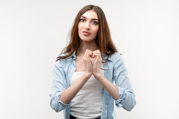 Pretty Young woman making heart symbol by hands on white background. Romantic concept.