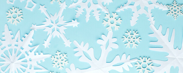 Christmas wallpaper with empty space for text. White Paper snowflakes on blue background. Blue winter holiday background with handmade snow, Xmas, New 2021 Year holiday banner