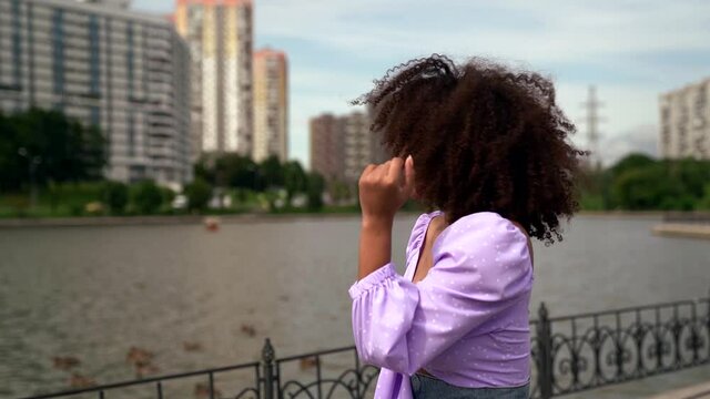 pretty creole woman is walking on city street and dancing, enjoying life and rejoicing