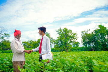 Indian farmer with agronomist at Cotton field and hand shaking