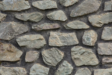 Graue Mauer aus Natursteinen im Querformat