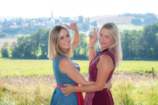Two bavarian girls making victory gesture