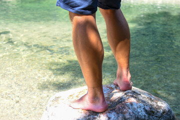 The legs of a man in a lake in nature