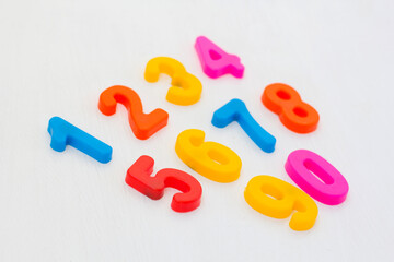 Colorful plastic numeral on white background. Learning numbers with fridge magnets. Arithmetic education in school
