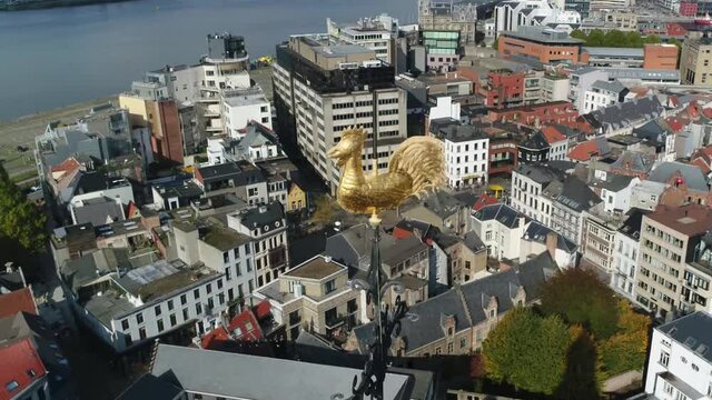 Aerial close up footage of Antwerp St. Paulus Church golden weather cock camera turning around the wind vane also showing the Belgian city center in the background 4k high resolution quality